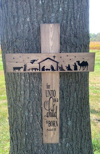 This Christmas Cross with Nativity offers a meaningful touch to your holiday decor. Handcrafted from wood and stained brown, this wall hanging features a black silhouette of a classic nativity scene with the phrase “For unto us a child is born”. Hang it in any interior room, or on a sheltered porch for an extra special accent piece.