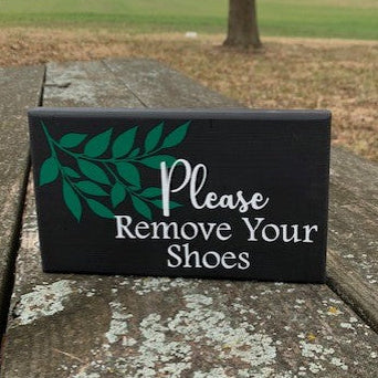 Decorative entry wall sign that asks guests to please remove their shoes. 
