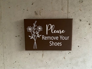 Minimalist home decor door sign that asks guest to remove their shoes. 