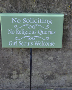 No Soliciting No Religious Queries Girl Scouts Welcome sign on a stake.  Light green paint with white lettering.  